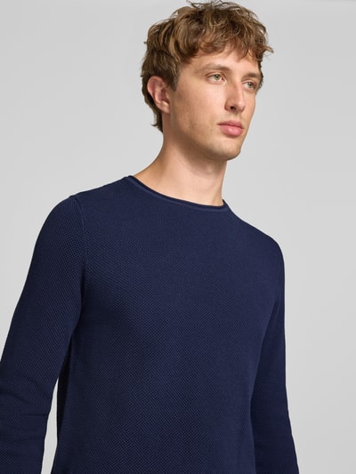 Männermodel trägt Slim Fit Pullover aus reiner Baumwolle von REVIEW in Dunkelblau, Strick-Optik, Rundhalsausschnitt, Nahaufnahme Oberkörper.