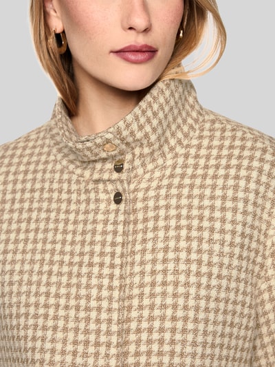 Vrouwenmodel draagt Jacke im Allover-Look mit Pattentaschen van Marc Cain in beige-bruin katoenmix met viscose, opstaande kraag, regular fit, detailopname bovenlichaam. Ruglengte maat 36: 59 cm, borstwijdte: 49 cm, mouwlengte: 45 cm.