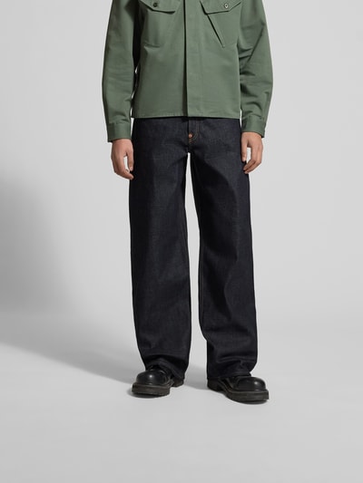 Männermodel trägt Wide Fit Jeans aus reiner Baumwolle von Kenzo in Dunkelblau mit Kontrastnähten und 5-Pocket-Design, Ganzkörperansicht von vorne.