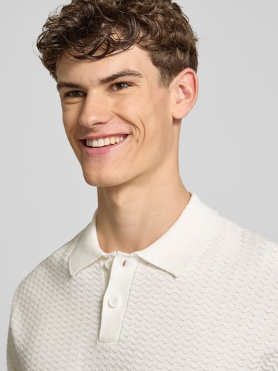 Männermodel trägt Relaxed Fit Poloshirt Modell 'FERDINAND' von Redefined Rebel aus Reine Baumwolle mit Knopfleiste, Nahaufnahme Oberkörper.