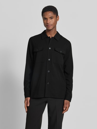 Männermodel trägt Relaxed Fit Hemdjacke mit Brusttaschen von Lindbergh aus Material-Mix mit Viskose-Anteil, Schwarz, Ganzkörperansicht von vorne.