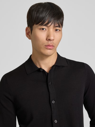 Männermodel trägt Strickjacke mit Polokragen Modell 'CAMICIA IN MAGLIA' von MARKUP aus reiner Baumwolle, Slim-Fit, schwarze Farbe, Nahaufnahme Oberkörper.