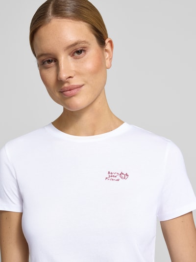 Modelka nosi Regular Fit T-Shirt aus reiner Baumwolle von Tom Tailor Denim, efekt: jednolity kolor, krój regular fit, aplikacja: wyhaftowany napis, dekolt: okrągły dekolt, rękaw: krótki rękaw, wykończenie materiału: dżersej, materiał: bawełna, zbliżenie na górną część ciała