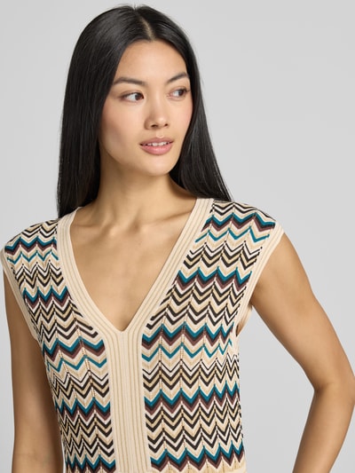 Vrouwenmodel draagt Slim Fit Maxikleid aus Viskose-Mix in Strick-Optik van zero, in beige met zigzagpatroon, V-hals, mouwloos design, ruglengte bij maat 36: 140 cm, borstwijdte bij maat 36: 39 cm, detailopname bovenlichaam.