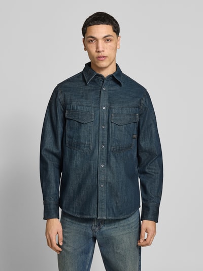 Männermodel trägt Regular Fit Jeanshemd mit Brusttaschen Modell 'Dakota' von G-Star Raw, Reine Baumwolle, Langärmelig, Kentkragen, Knopfleiste, Ganzkörperansicht von vorne.