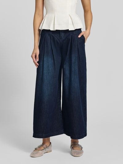 Vrouwenmodel draagt donkerblauwe Palazzo-jeans met wijde benen van mix van katoen en lyocell, model 'Liv' van Buena Vista, bandwijdte maat S 37 cm, binnenbeenlengte 63 cm, met achterzakken en knoopsluiting, detailopname voorkant.