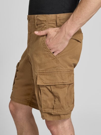 Männermodel trägt Straight Fit Shorts mit Cargo-Taschen Modell 'Core' von GAP aus Baumwoll-Mix in Braun, Nahaufnahme Oberkörper, seitliche Vorderansicht, Herren Shorts mit Eingriffstaschen, Gesäßtaschen, Knopf- und Reißverschluss, Bundweite 43 cm, Innenbeinlänge 27 cm.