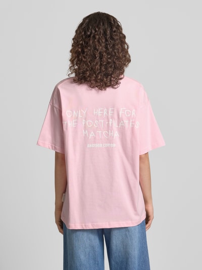 Frauenmodel trägt T-Shirt mit Logo-Stitching von ANOTHER COTTON LAB in Rosa, Reine Baumwolle, Lockerer-Schnitt, Rückenlänge 66 cm, Ganzkörperansicht Rückansicht.