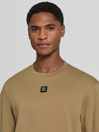 Männermodel trägt Regular Fit T-Shirt aus reiner Baumwolle Modell 'Dalile' von HUGO, beige, glatte Textur, Nahaufnahme Oberkörper, Herren T-Shirt von HUGO
