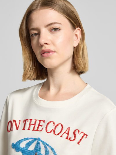 Frauenmodel trägt Relaxed Fit T-Shirt mit Ziersteinbesatz von Rich & Royal in Creme, reine Baumwolle, Rundhalsausschnitt, Nahaufnahme Oberkörper