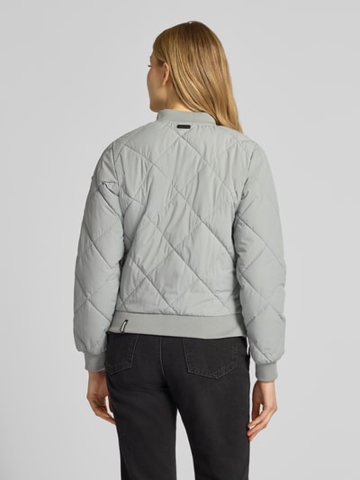 Kobiece modelka nosi jasnoszarą Steppjacke mit Knopfleiste Modell 'ANGE2' od khujo, krój regular fit, z stójką, tekstura pikowana, Ganzkörperansicht Rückansicht.