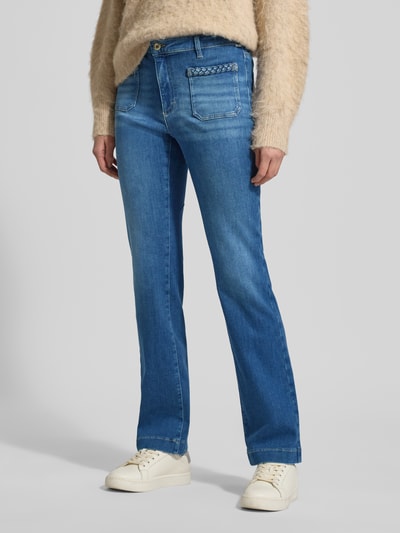 Frauenmodel trägt Flared Fit Jeans mit Flecht-Detail Modell 'Mary' von BRAX aus elastischem Baumwoll-Mix, aufgesetzte Taschen, Knopf- und Reißverschluss, Damen Jeans, Ganzkörperansicht von vorne.
