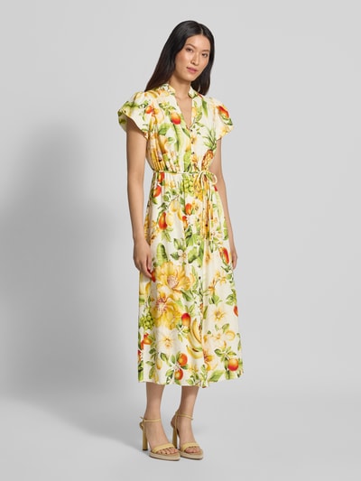 Frauenmodel trägt Abendkleid aus Leinen-Viskose-Mix Modell 'Posie' von Forever New mit gelb-grünem Blumenmuster und Taillenband, Ganzkörperansicht von vorne. Damen Abendkleid, taillierte Passform, Stehkragen mit V-Ausschnitt, kurzärmeliges Design.
