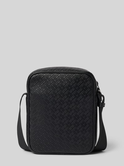Produktfoto, rechteckige Umhängetasche mit Logo-Detail Modell 'EMBOSSED FLAG' von Tommy Hilfiger in schwarzer Lederoptik mit geprägtem Monogramm-Muster, Reißverschluss, strukturiertes Kunstleder und Schulterriemen vor grauem Hintergrund.