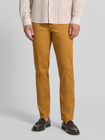 Männermodel trägt Stoffhose aus Baumwoll-Mix mit Viskose-Anteil Modell 'Cadiz' von Brax in Senfgelb, Ganzkörperansicht von vorne. Herren Stoffhose von Brax.