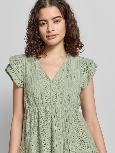 Frauenmodel trägt Tailliertes Blusenkleid aus Baumwoll-Mix Modell 'HELENA' von Only, Optik: Unifarben, V-Ausschnitt, Stickerei, Kurzarm, Nahaufnahme Oberkörper.