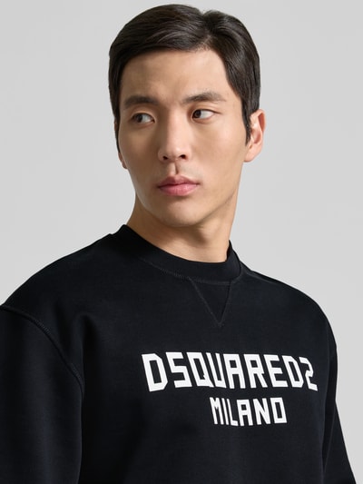 Männermodel trägt Cool Fit Sweatshirt aus reiner Baumwolle von Dsquared2 mit Label-Print in Schwarz, Nahaufnahme Oberkörper.