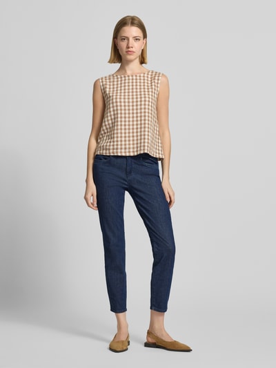 Frauenmodel trägt Slim Fit Jeans aus Baumwoll-Mix Modell 'SHAKIRA' von Brax in Denim-Optik, Mid Waist, Label-Patch, Gürtelschlaufen, Knopf und verdeckter Reißverschluss, Ganzkörperansicht von vorne.