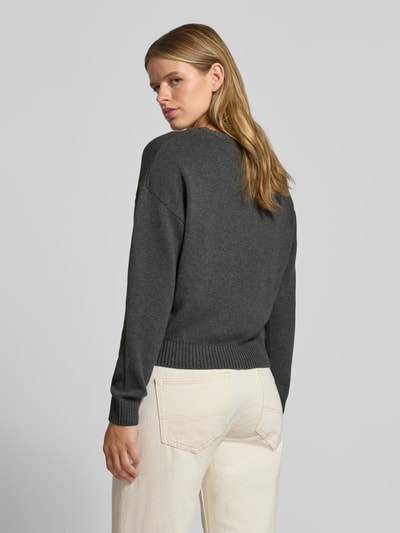 Frauenmodel trägt Strickpullover aus reiner Baumwolle von REVIEW in Dunkelgrau mit gerippten Abschlüssen, lockere Passform, Ganzkörperansicht Rückansicht.