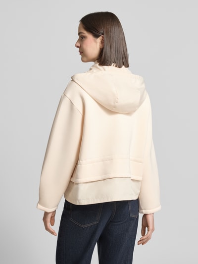 Frauenmodel trägt Jacke mit Pattentaschen und Kordelzug an der Taille von LIU JO SPORT in Creme, Viskose-Mix mit Stretch-Anteil, Kapuze, Gerader-Schnitt, Zweiwege-Reißverschluss, Logo-Stitching, Rückenlänge 59 cm, Schulterbreite 54 cm, Brustweite 64 cm, Ärmellänge 53 cm, glatte Textur, Ganzkörperansicht Rückansicht.