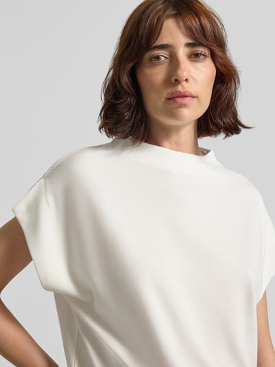 Frauenmodel trägt T-Shirt aus Viskose-Mix Modell 'Ujolina' von someday, cremefarben, Stehkragen, Kappärmel, Nahaufnahme Oberkörper.