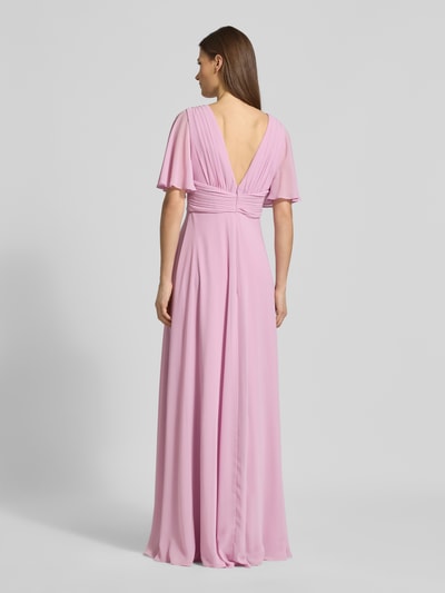 Modelka prezentuje Sukienka wieczorowa Regular Fit Abendkleid mit V-Ausschnitt von Jake*s Cocktail, szyfon, krój regular fit, dekolt w serek, efekt plisów, rękaw o dł. 1/2, dekolt na plecach, wszyty zamek błyskawiczny, nieprześwitująca halka, długość tyłu w rozmiarze 36: 126 cm, szerokość w rozmiarze 36: 40 cm, długość rękawów w rozmiarze 36: 29 cm, jasnoróżowy kolor, widoczne delikatne drapowania, gładka faktura, pełny widok sylwetki od tyłu