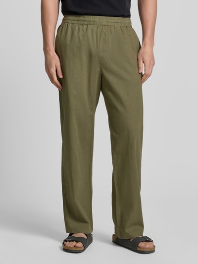 Männermodel trägt Regular Fit Hose mit Eingrifftaschen van Wood Wood, mix van linnen en katoen, olivegroen, elastische band, steekzakken, regular fit, bandwijdte maat M 42 cm, binnenbeenlengte maat M 77 cm, heren broek, ganzkörperansicht van voren
