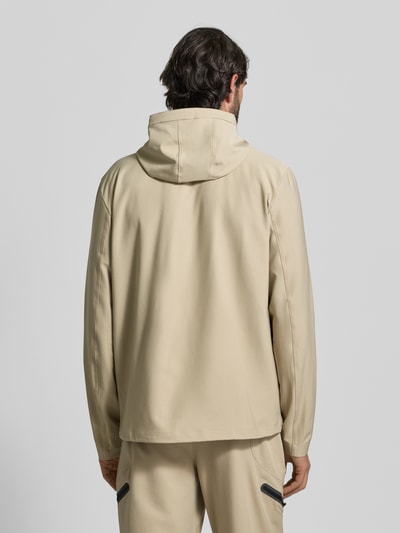 Männermodel trägt Regular Fit Jacke mit Logo-Print Modell 'Unstoppable' von Under Armour im elastischen Material-Mix, Kapuze, Reißverschluss, Eingrifftaschen, Rückansicht Ganzkörperansicht.