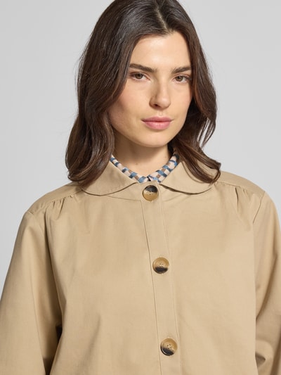 Frauenmodel trägt Relaxed Fit Jacke mit Umlegekragen Modell 'Viola' von Lollys Laundry in Beige mit durchgängiger Knopfleiste und Eingrifftaschen, Nahaufnahme Oberkörper. Rückenlänge bei Größe S: 62 cm, Schulterbreite: 38 cm, Brustweite: 49 cm, Ärmellänge: 60 cm.