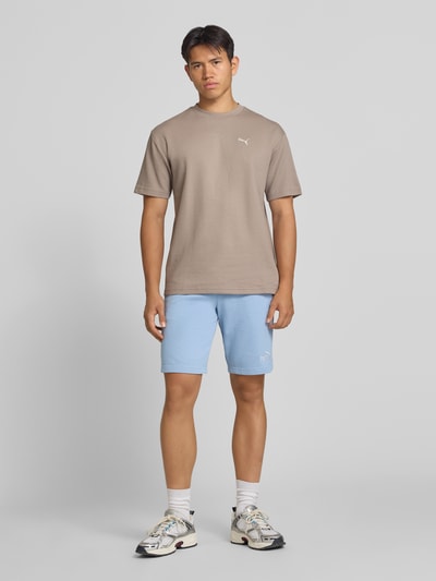 Männermodel trägt Shorts mit Logo und elastischem Bund von PUMA in Hellblau, Baumwoll-Mix, Regular Fit, Ganzkörperansicht von vorne.