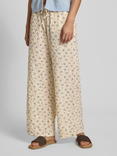 Frauenmodel trägt Wide Leg Pull-on-Hose aus Seersucker mit Kordelzug von REVIEW, Elastischer-Material-Mix, creme mit Blumenmuster, Nahaufnahme Unterkörper, Ganzkörperansicht von vorne.