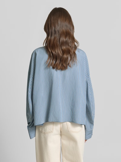 Männermodel trägt Relaxed Fit Bluse aus mieszanka wiskozy model 'OSHIA' od Drykorn, niebieskie paski, kołnierzyk koszulowy, długość tyłu 59 cm, długość rękawów 65 cm, Ganzkörperansicht Rückansicht.