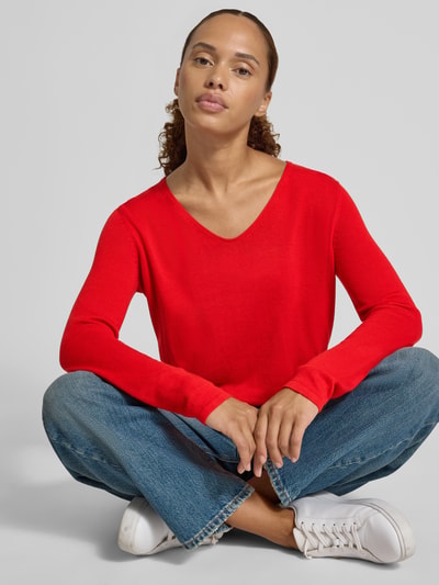 Frauenmodel trägt Regular Fit Pullover aus Baumwoll-Mix von Tom Tailor in leuchtendem Rot, kombiniert mit blauer Jeans, Nahaufnahme Oberkörper. Damen Pullover von Tom Tailor