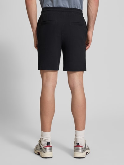 Männermodel trägt Loose Fit Sweatshorts aus Bio-Baumwoll-Mix Modell 'KIAN' von Only & Sons, Optik: Unifarben, Ganzkörperansicht Rückansicht.