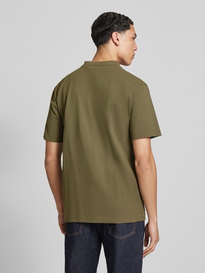 Männermodel trägt Regular Fit Poloshirt aus reiner Baumwolle Modell 'Core' von G-Star Raw in Olivgrün, glatte Struktur, Ganzkörperansicht Rückansicht. Rückenlänge bei Größe M: 72 cm, sichtbares Label-Detail, Polokragen, Regular Fit.
