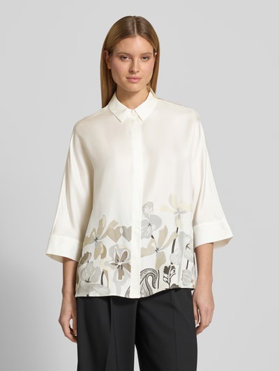 Frauenmodel trägt Relaxed Fit Hemdbluse aus reiner Seide mit Floralem-Print von HERZENS, elfenbeinfarbene Grundfarbe, schwarze Hose, 3/4-Arm, Hemdblusenkragen, durchgängige Knopfleiste, Rückenlänge 73 cm, Ärmellänge 43 cm, Nahaufnahme Oberkörper.