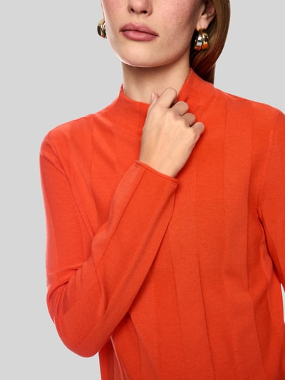 Frauenmodel trägt Strickpullover aus Schurwolle-Mix mit Stehkragen von Marc Cain in Orange, glatte Textur, Nahaufnahme Oberkörper, Damen Strickpullover, Schurwolle-Mix mit Kaschmir-Anteil, Slim Fit, Stehkragen, Label-Detail