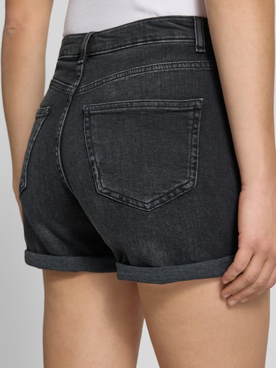 Frauenmodel trägt Regular Fit Jeansshorts aus Baumwoll-Mix Modell 'JOSEPHINE' von Only in dunkler Denim-Optik mit Label-Patch, Gürtelschlaufen, 5-Pocket-Design, Nahaufnahme Rückansicht.
