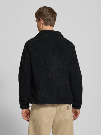 Männermodel trägt zwarte fleecejack van JACK & JONES met Teddybont, regular fit, opstaande kraag, Model 'SOHO', Ganzkörperansicht Rückansicht. Ruglengte maat M: 68 cm, Mouwlengte maat M: 69 cm, Steekzakken, borstzak met rits, logo.