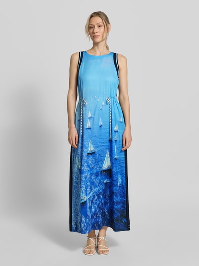 Frauenmodel trägt Maxikleid aus reinem Lyocell mit Allover-Foto-Print von Marc Cain in Blau mit taillierter Passform, Rundhalsausschnitt und Ärmelloses-Design, mit Rückenlänge 134 cm und Brustweite 47 cm, Ganzkörperansicht von vorne.
