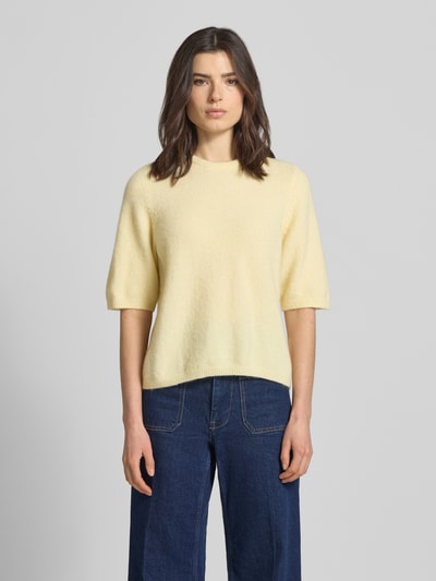 Frauenmodel trägt Relaxed Fit T-Shirt aus Alpaka-Mix Modell 'Alpha' von Gestuz, elastischer Alpaka-Mix mit Escorial-Woll-Anteil, Damen T-Shirt in zartem Gelb, Strick-Optik, Halbarm, Rundhalsausschnitt, elastische Abschlüsse, Rückenlänge 56 cm, Ärmellänge 34 cm, Ganzkörperansicht von vorne.