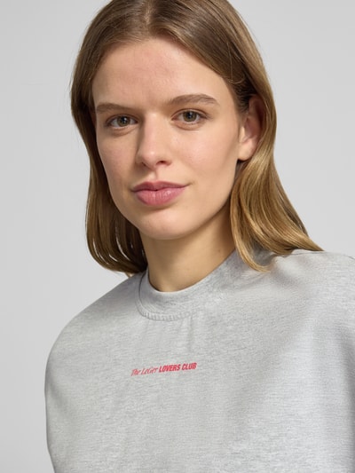 Kobiece model nosi Oversized T-Shirt mit Rundhalsausschnitt Modell 'Lotte' von LeGer by Lena Gercke z bawełny, nadruk z logo, krój oversized, okrągły dekolt, damski t-shirt, długość tyłu w rozmiarze 36: 66 cm, zbliżenie na górną część ciała.