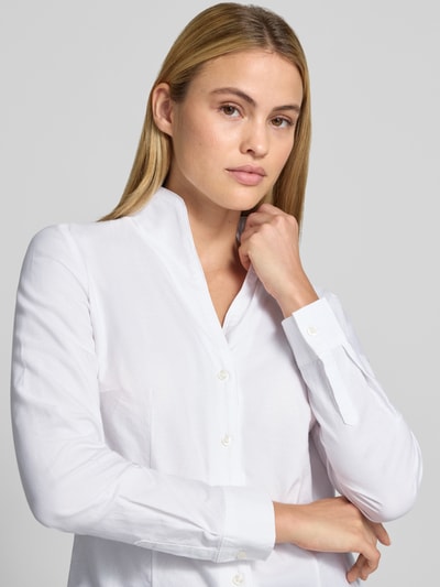 Frauenmodel trägt Regular Fit Hemdbluse aus reiner Baumwolle von Christian Berg Woman, weiß, Stehkragen, Langarm, Nahaufnahme Oberkörper.