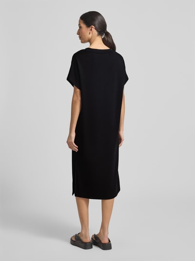 Frauenmodel trägt T-Shirt-Kleid mit V-Ausschnitt von Soyaconcept, schwarz, gerader Schnitt, Material-Mix mit Modal, Midikleid, Ganzkörperansicht Rückansicht.