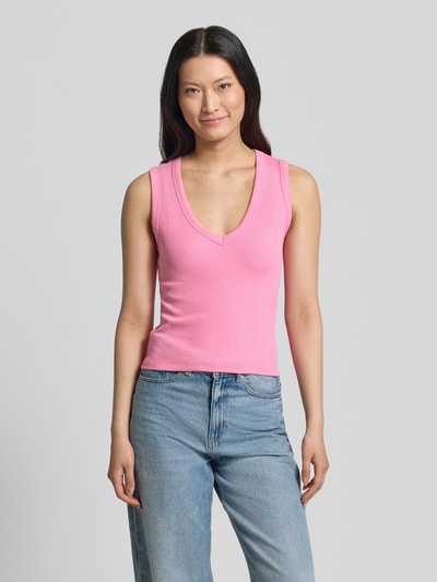 Kobiece model prezentuje Slim Fit Tank Top aus Baumwoll-Mix Modell 'CHLOE' von Vero Moda, jednokolorowy różowy, dekolt w serek, szerokie ramiączka, prążkowana faktura, mieszanka bawełny, całkowity widok z przodu.