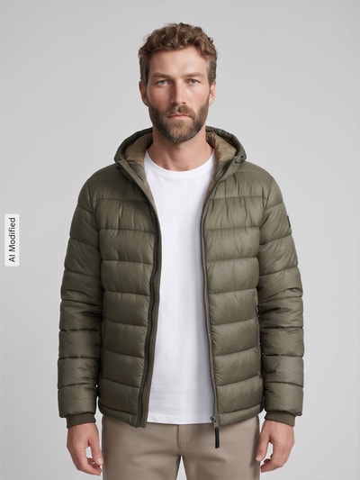 Männermodel trägt Regular Fit Steppjacke mit Storm Cuffs Modell 'BAVENO' von Strellson in Olivgrün, glänzende Steppung, Ganzkörperansicht von vorne, KI-modifiziertes Bild.