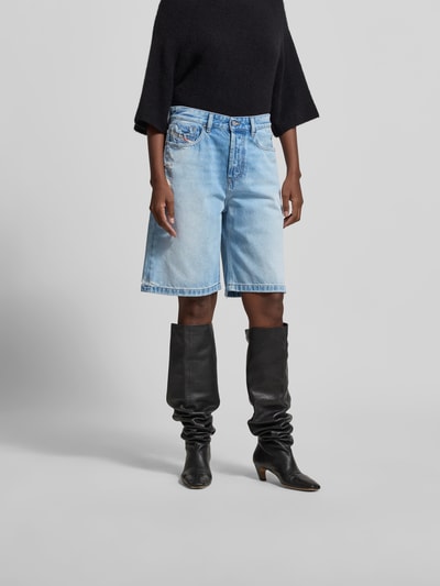 Frauenmodel trägt Relaxed Fit Jeansshorts aus Reiner Baumwolle von Diesel in hellem Blau, 5-Pocket-Design, Destroyed-Look, Knopf-Reißverschluss, Ganzkörperansicht von vorne.