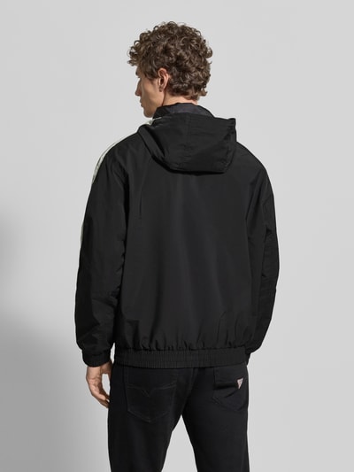 Männermodel trägt Regular Fit Jacke mit Kapuze Modell 'BAVO2621' von HUGO, Optik: Unifarben, elastischer Abschluss, Ganzkörperansicht Rückansicht.