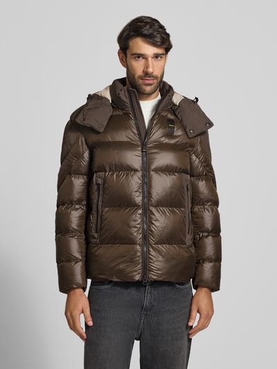 Męski model nosi Steppjacke mit Zweiwege-Reißverschluss Modell 'KIERNAN' od Blauer USA, krój regular fit, kaptur, detal z logo, brązowa, tekstura pikowana, całkowity widok z przodu, długość tyłu w rozmiarze M: 67 cm, szerokość ramion w rozmiarze M: 49 cm, szerokość klatki piersiowej w rozmiarze M: 59 cm, długość rękawa w rozmiarze M: 65 cm