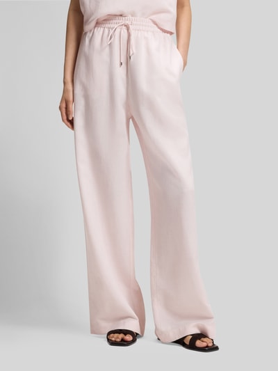 Vrouwenmodel draagt Loose Fit Leinenhose aus Lyocell-Leinen-Mix Modell 'TAVATI2_TI' van BOSS, look: effen kleuren, pasvorm: loose fit, labelapplicatie, tunnelkoordsluiting, boord elastisch, zij-steekzakken, materiaal: mix van lyocell en linnen, detailopname onderlichaam.